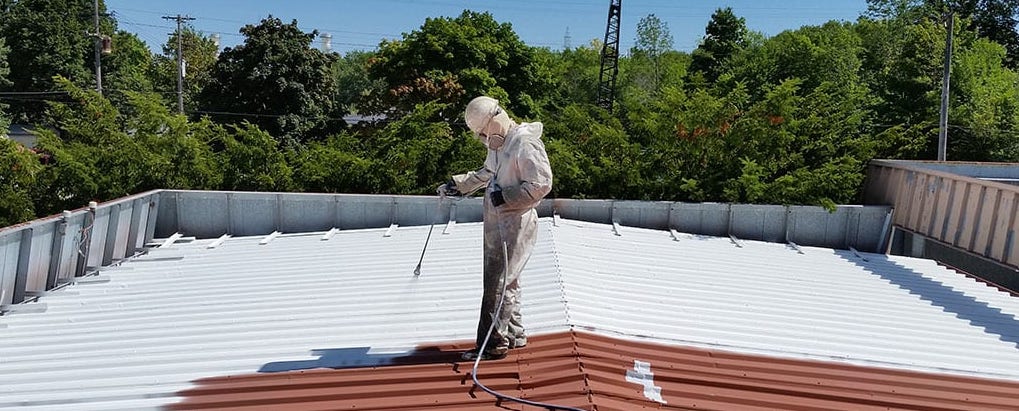 Person applying coating on roof