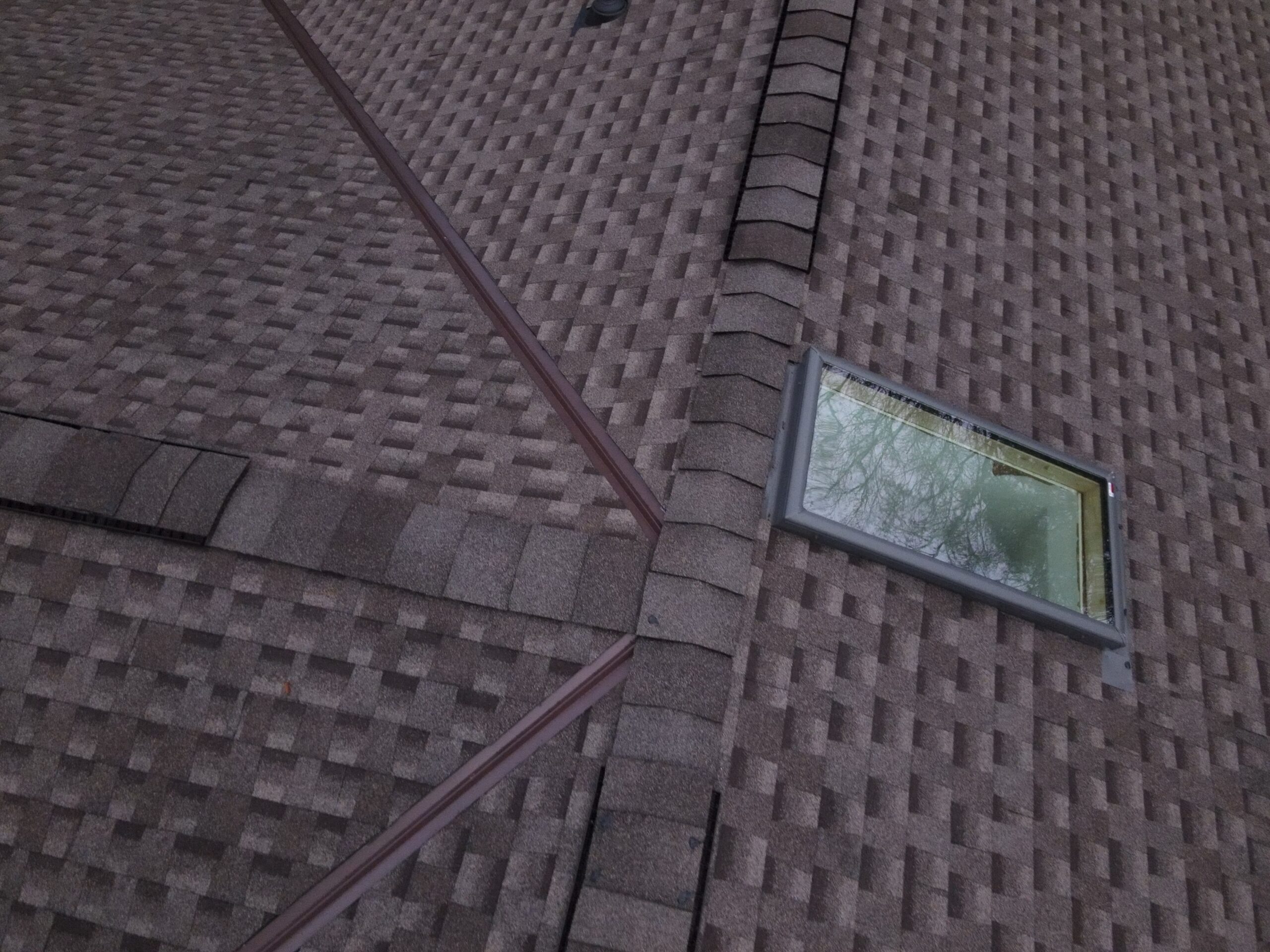 Roof with skylight and shingles