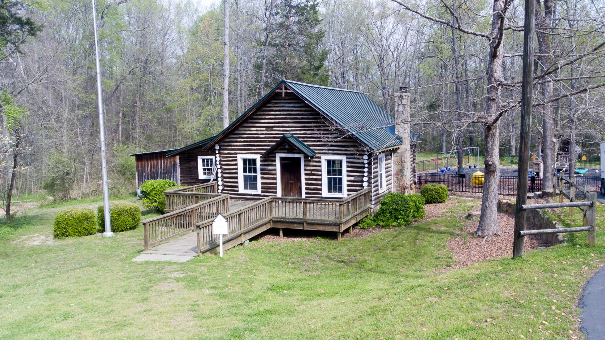 Log cabin surrounded by trees and grass