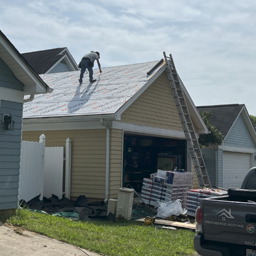 Worker installing roofing materials outdoors