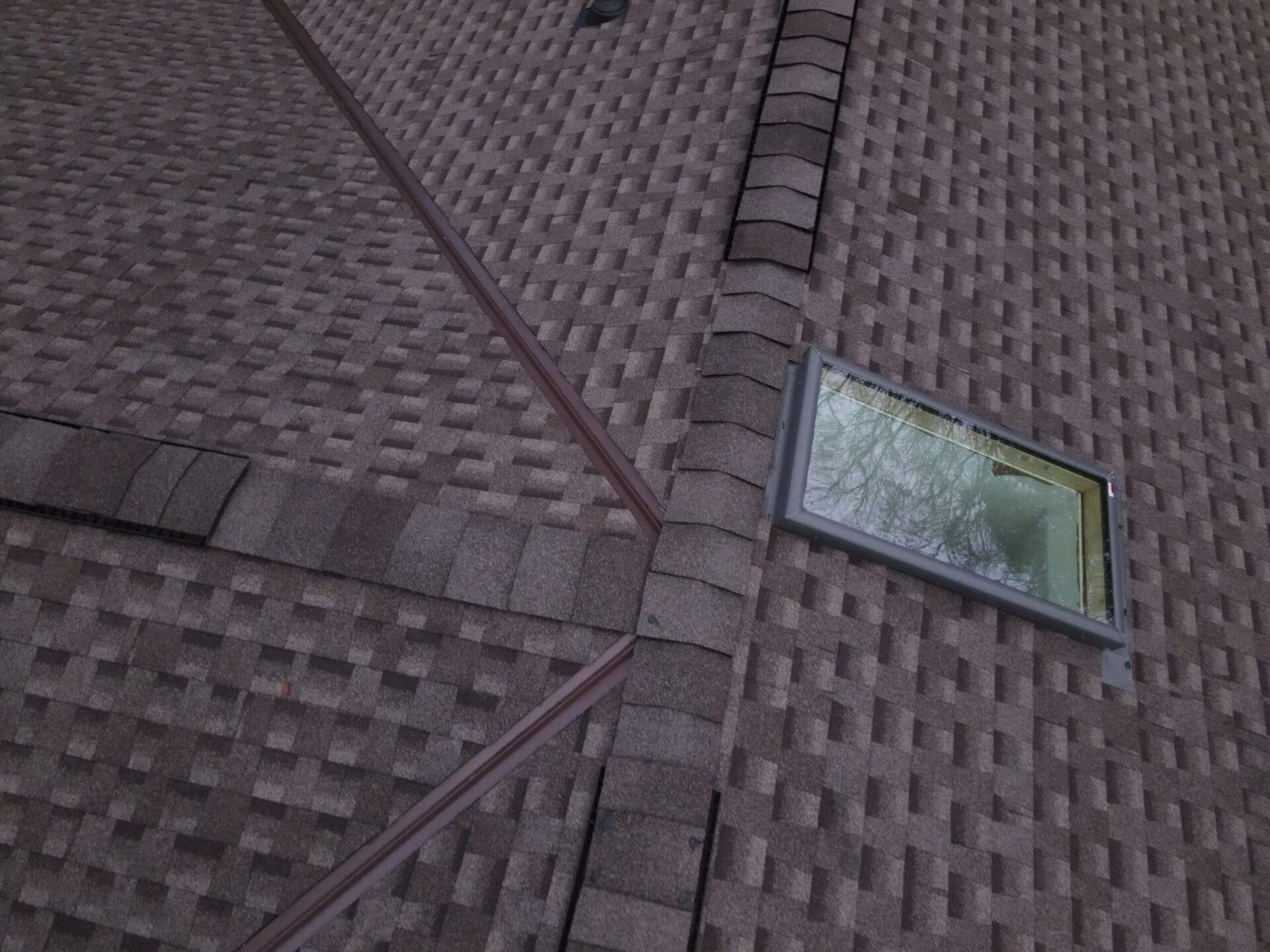 Roof with skylight and shingles