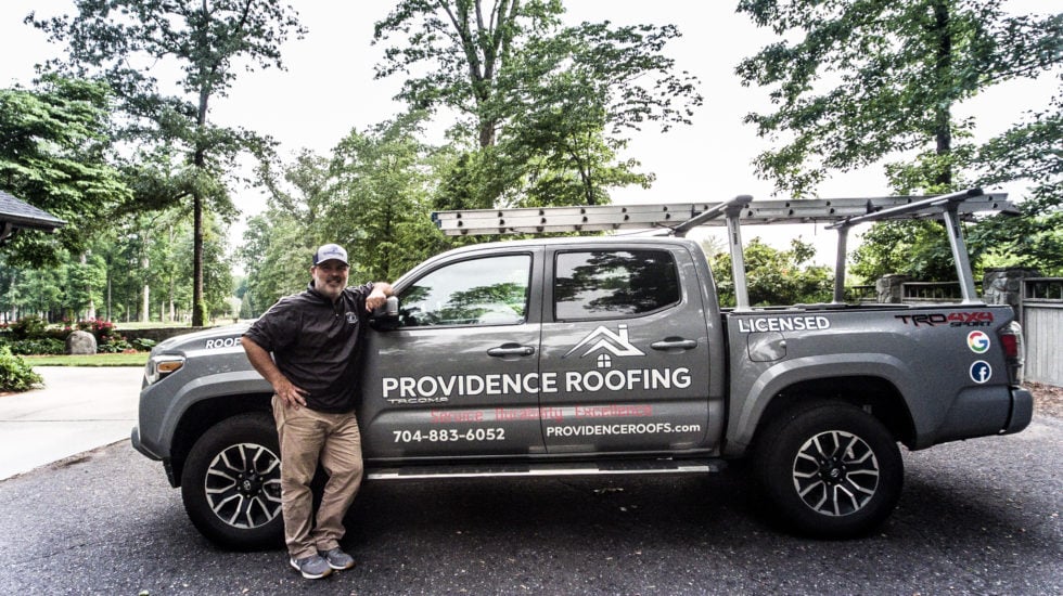 Roofing truck parked in residential area.
