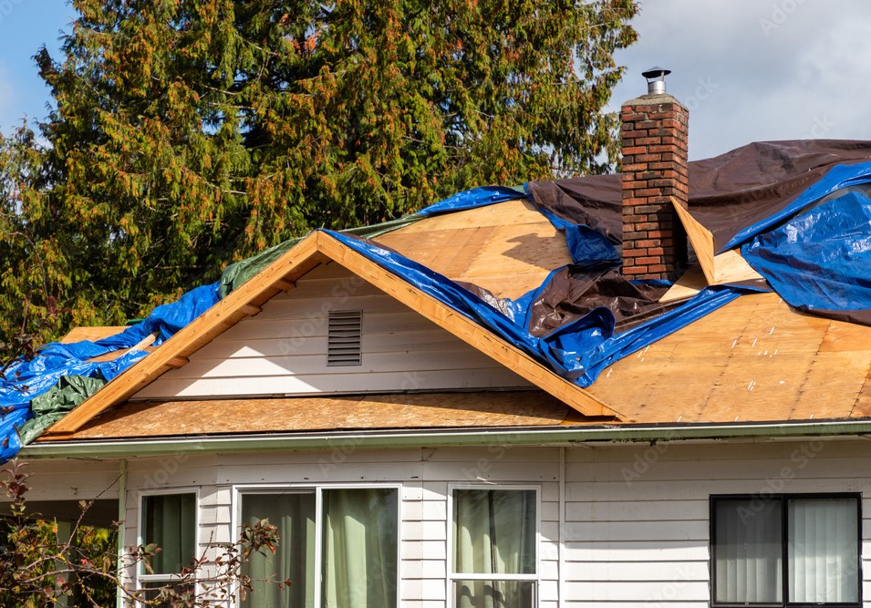 House roof under construction with tarps
